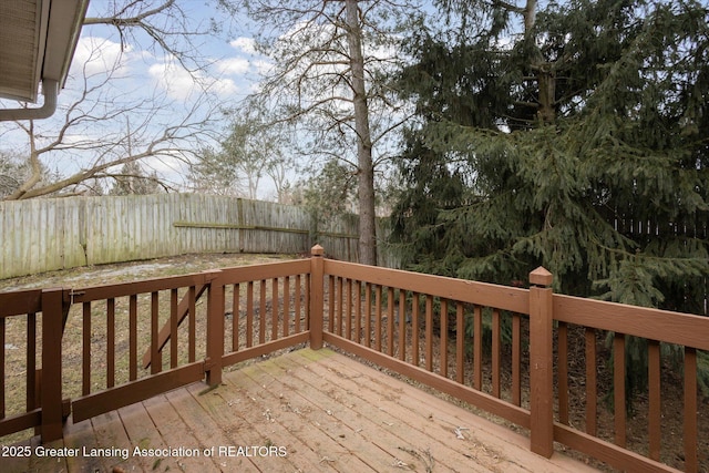 wooden terrace with a fenced backyard