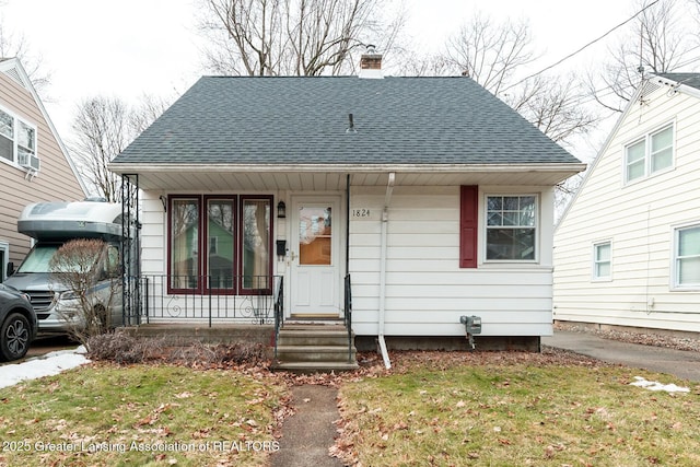 bungalow with a chimney, a porch, cooling unit, and roof with shingles