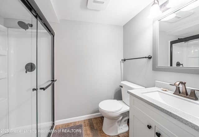 full bath with toilet, a stall shower, wood finished floors, and vanity