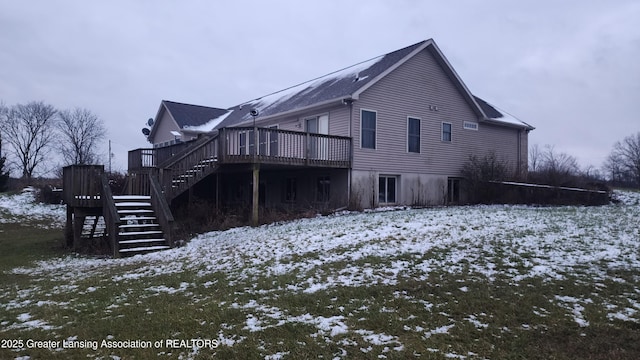 view of snowy exterior with stairs and a wooden deck