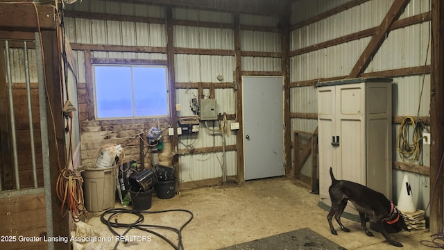 misc room featuring metal wall and electric panel