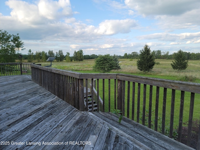 wooden deck featuring a rural view and a yard