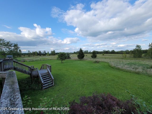 view of yard with a rural view and stairs