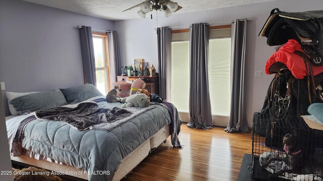 bedroom with a textured ceiling and wood finished floors