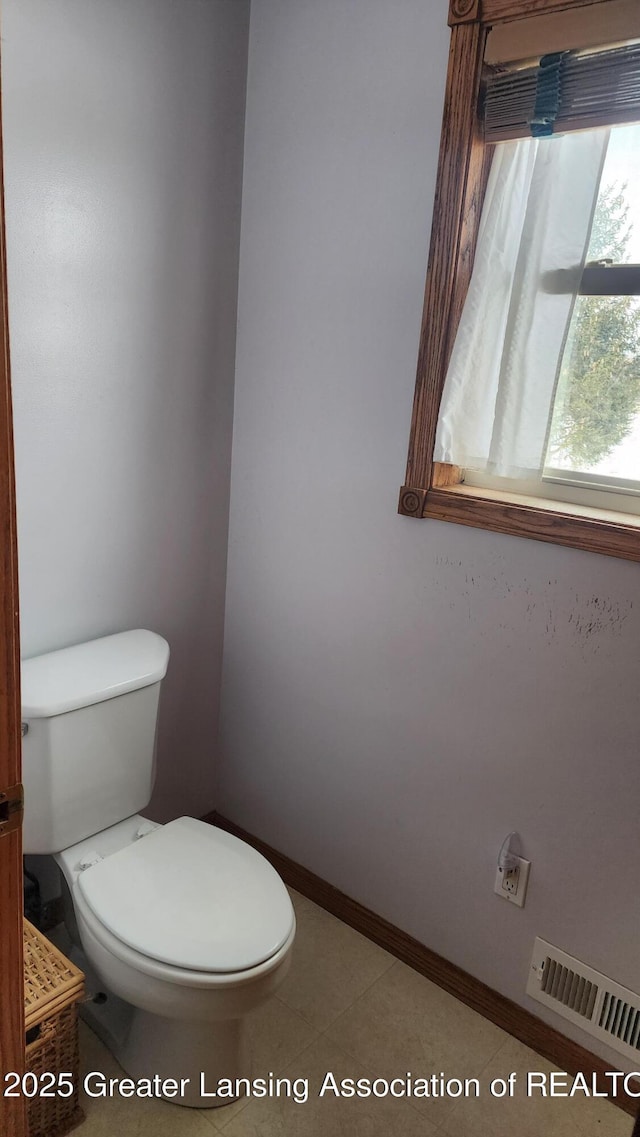 bathroom featuring toilet, visible vents, and baseboards