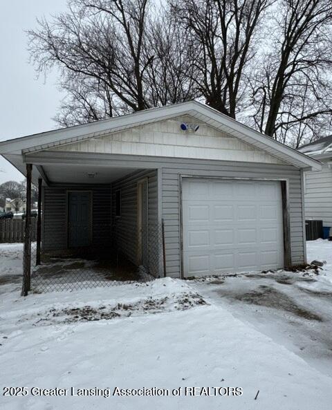 snow covered garage with a garage