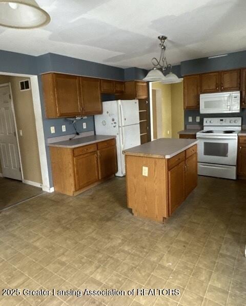 kitchen featuring a center island, white appliances, and brown cabinets