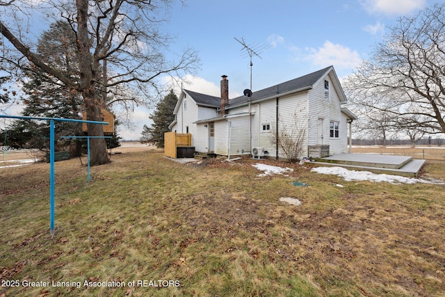 rear view of property featuring a patio area, a chimney, and a yard