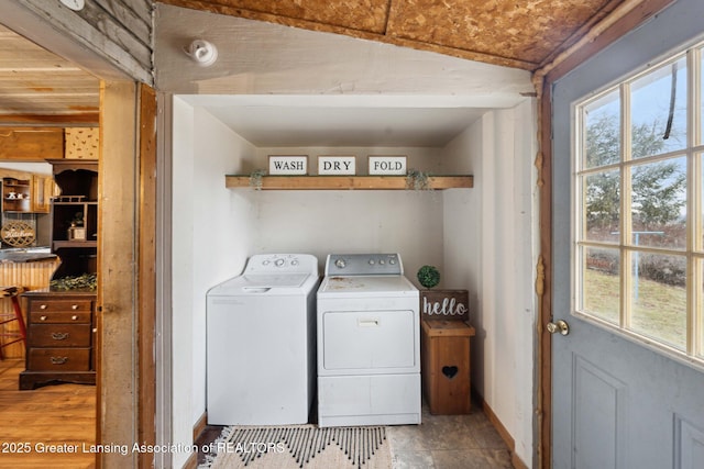 clothes washing area featuring laundry area, baseboards, and washing machine and clothes dryer