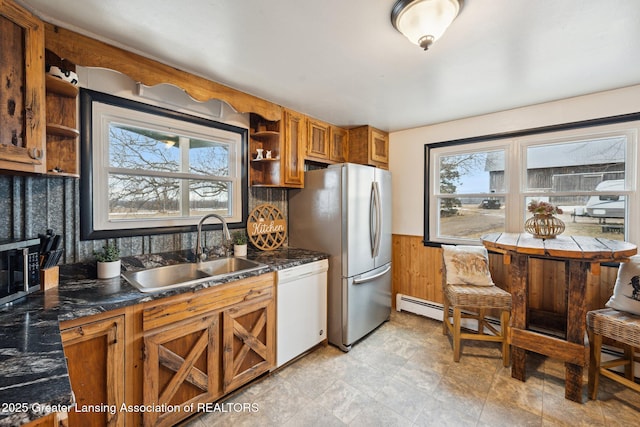 kitchen featuring appliances with stainless steel finishes, brown cabinets, a sink, and open shelves