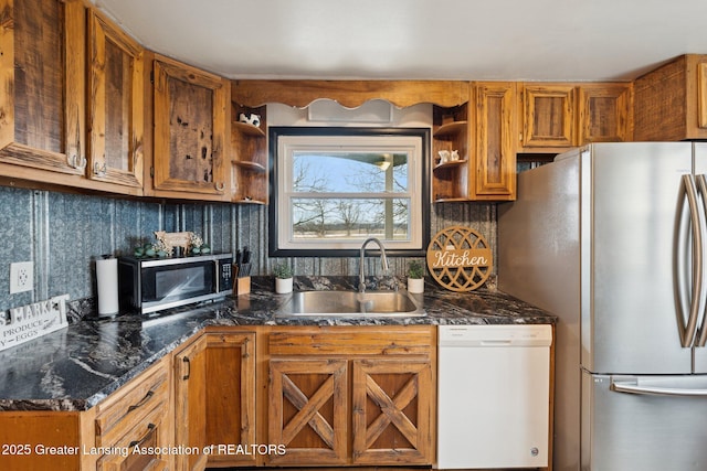 kitchen featuring brown cabinetry, decorative backsplash, stainless steel appliances, open shelves, and a sink