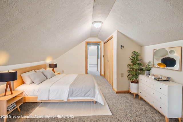 carpeted bedroom with lofted ceiling, a textured ceiling, and baseboards