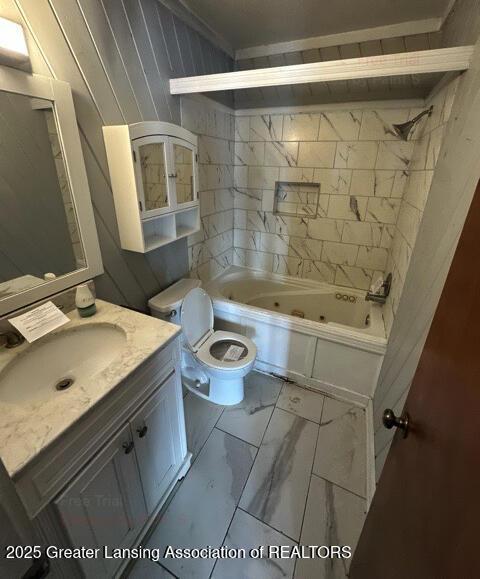 bathroom featuring a combined bath / shower with jetted tub, marble finish floor, vanity, and toilet