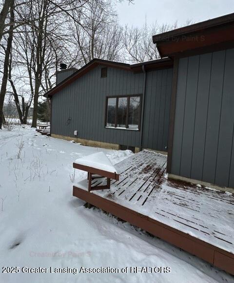 snow covered property featuring a chimney