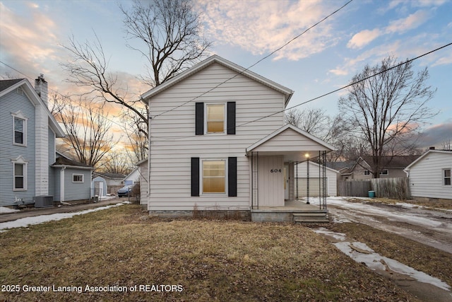 traditional home featuring cooling unit and fence