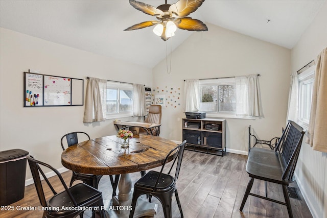 dining area with lofted ceiling, ceiling fan, wood finished floors, and baseboards