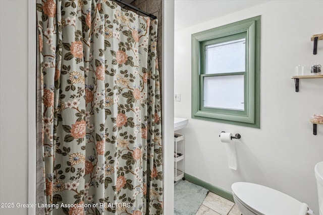 full bath with curtained shower, toilet, and baseboards