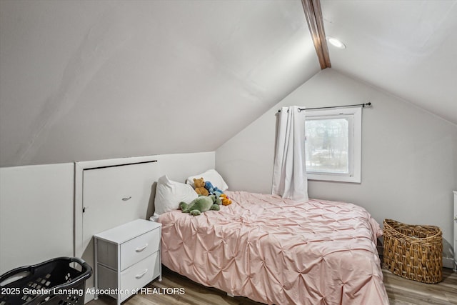 bedroom with lofted ceiling and wood finished floors