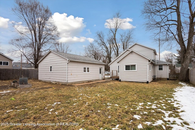 rear view of property with an outbuilding, a fenced backyard, and a lawn