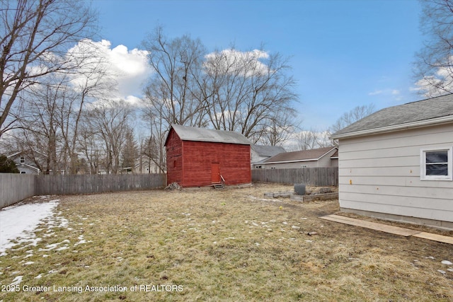 view of yard with a storage shed, a fenced backyard, and an outdoor structure