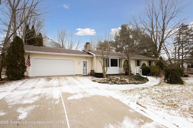 ranch-style house with a garage, driveway, and a chimney