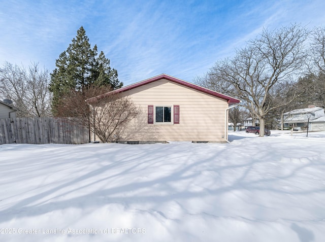 snow covered property featuring fence