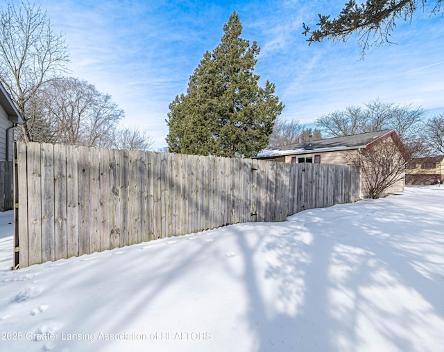 yard covered in snow with fence