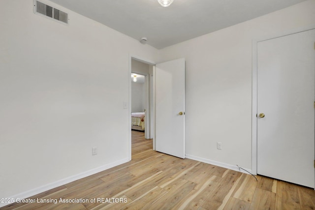 unfurnished bedroom featuring light wood-style flooring, visible vents, and baseboards