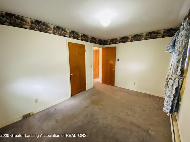 empty room featuring carpet and baseboards