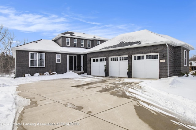 view of front of house featuring an attached garage, concrete driveway, and brick siding