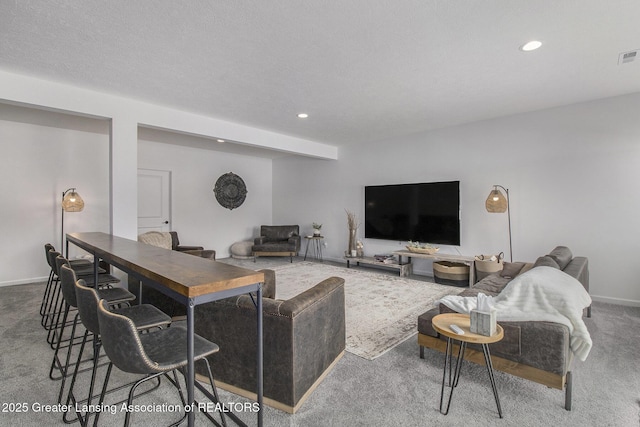 living area featuring a textured ceiling, recessed lighting, carpet floors, visible vents, and baseboards