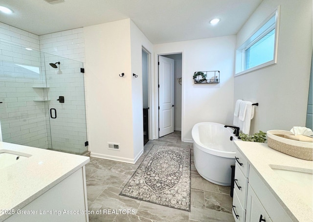 full bathroom featuring a stall shower, baseboards, a freestanding bath, and vanity