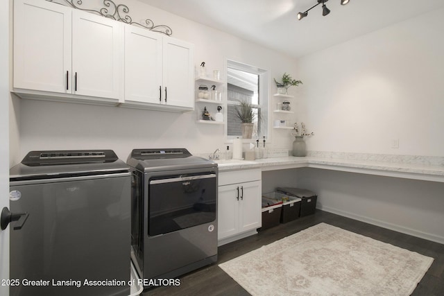 clothes washing area with a sink, dark wood-style flooring, washing machine and dryer, and cabinet space