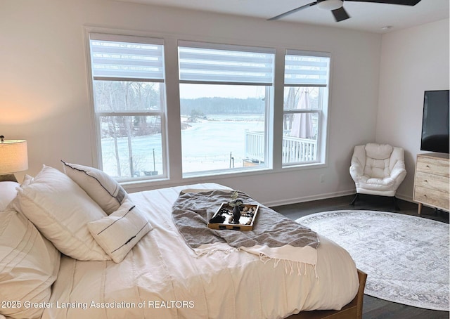 bedroom featuring ceiling fan, baseboards, and wood finished floors