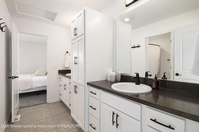 ensuite bathroom with wood tiled floor, vanity, and ensuite bath