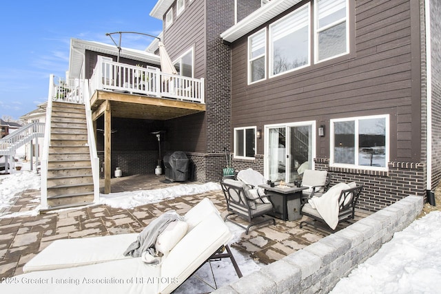 view of patio / terrace featuring a fire pit, stairway, a wooden deck, and a grill