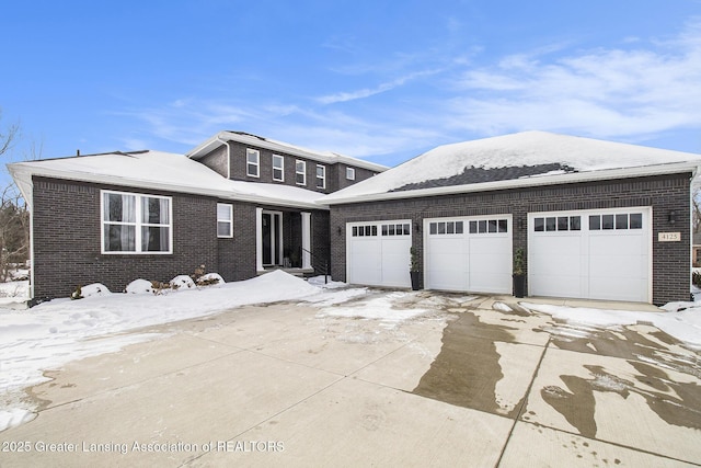 view of front of house featuring brick siding, an outdoor structure, driveway, and an attached garage