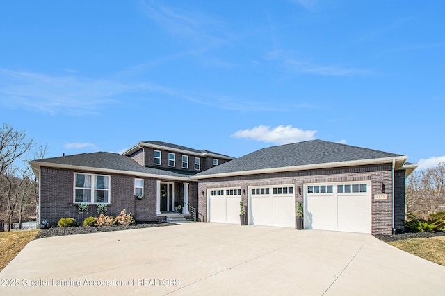 prairie-style house with brick siding, an attached garage, roof with shingles, and driveway