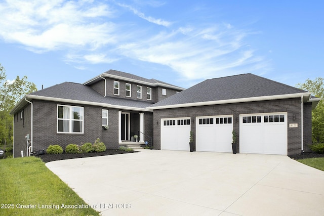 4125 Harbour Cv, Lansing, MI 48911 - view of front of home with driveway, an attached garage, brick siding, and a shingled roof