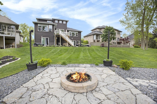 4125 Harbour Cv, Lansing, MI 48911 - rear view of property with a fire pit, stairway, a lawn, and a patio
