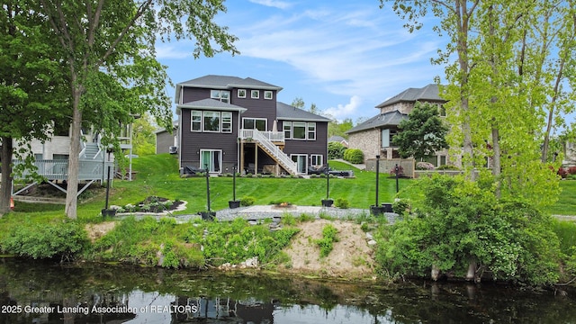 4125 Harbour Cv, Lansing, MI 48911 - back of house featuring stairway, a deck with water view, and a lawn