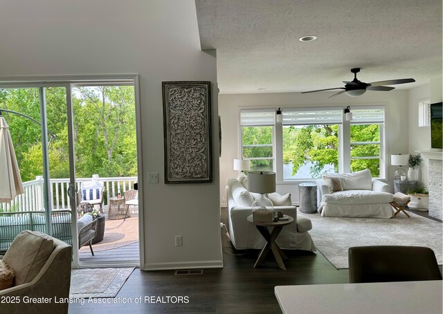 4125 Harbour Cv, Lansing, MI 48911 - living room featuring a ceiling fan, dark wood finished floors, a textured ceiling, and baseboards