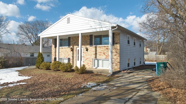 view of front of property with fence and brick siding