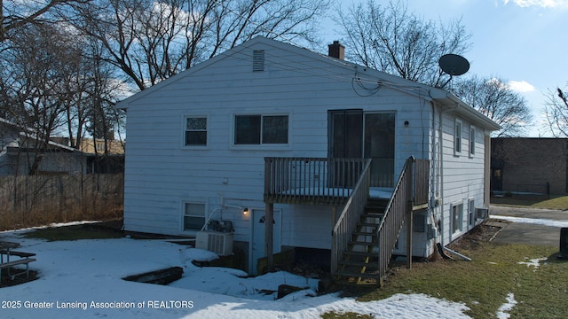 back of property with central AC unit, stairway, and a chimney