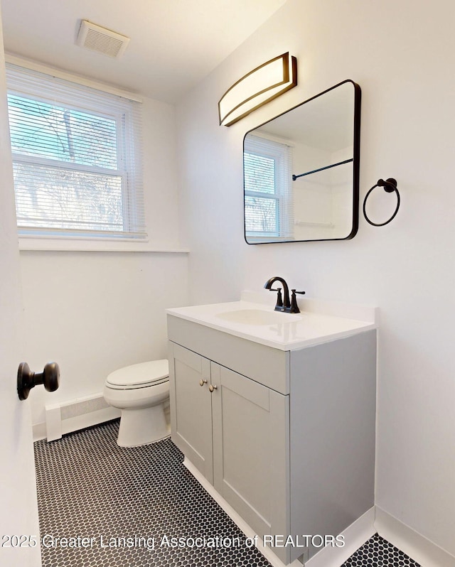 bathroom with visible vents, plenty of natural light, vanity, and toilet