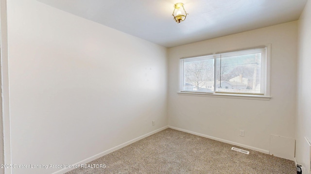 carpeted spare room with visible vents and baseboards