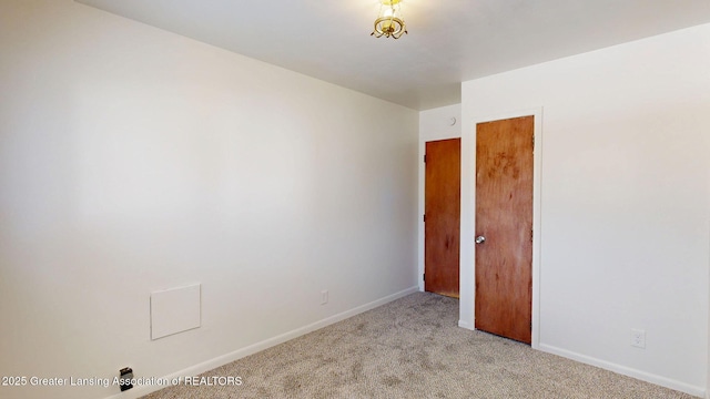 empty room with baseboards and light colored carpet