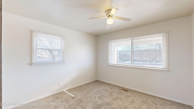 unfurnished room with light carpet, plenty of natural light, and visible vents