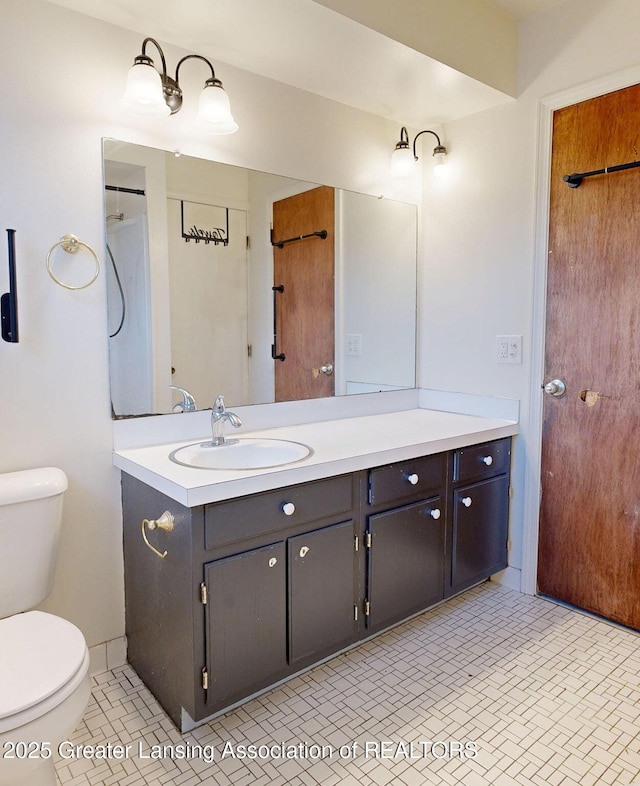 full bath with tile patterned flooring, vanity, and toilet