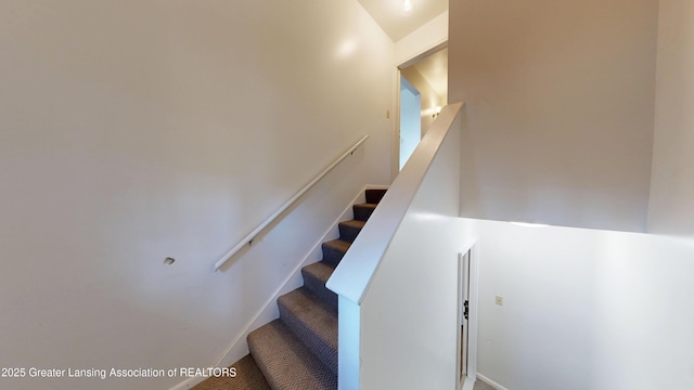 stairway with baseboards and carpet flooring